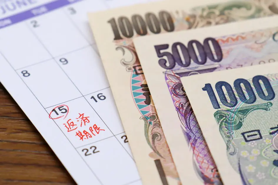 Japanese is written on the calendar. Images related to repayment of debts, scholarships, and loans. Translation: due date for repayment.