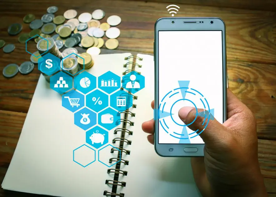 Hand holding a smart phone with finger on white touch screen. Rows of coins stack in banking and saving concept with money and finance icons.