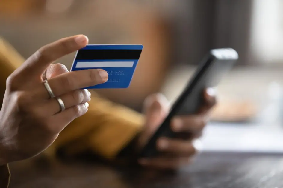 Close up cropped view African female do online shopping use credit card and smart phone. Cashless payment, easy quick money transfer using mobile application, secure e-pay, e-bank app usage concept