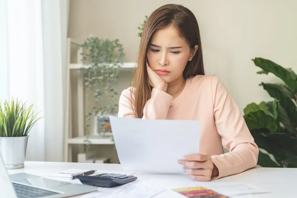 Business financial concept, stressed asian young woman hand checking list statement of credit card for calculate accounting expense, tax for payment on due deadline, trying to find money to pay debt.